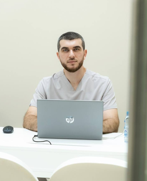 Dr Gani seated at a laptop in the Longevium clinic