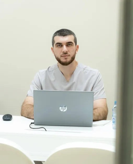 Dr Gani seated at a laptop in the Longevium clinic